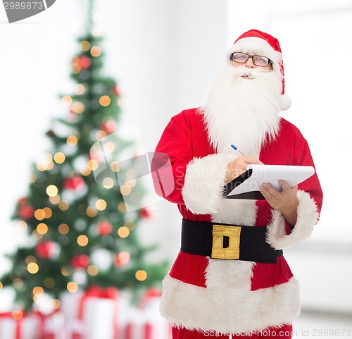 Image of man in costume of santa claus with notepad