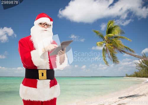 Image of man in costume of santa claus with tablet pc