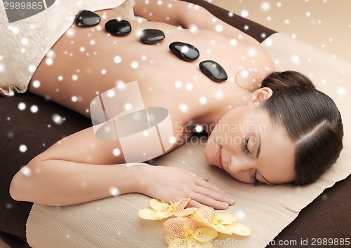 Image of woman in spa salon with hot stones