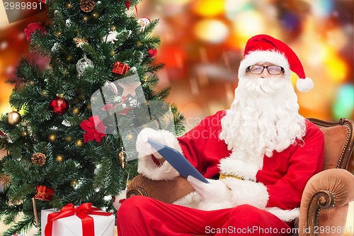 Image of man in costume of santa claus with tablet pc