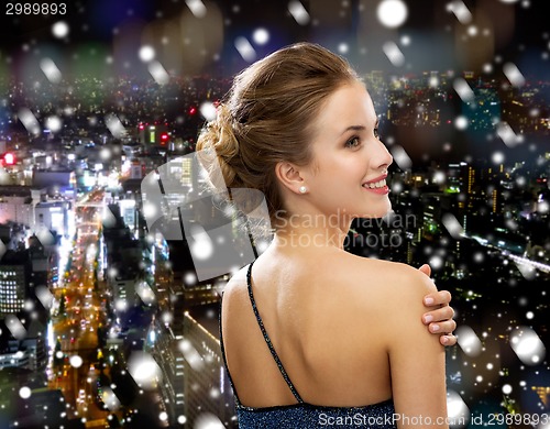 Image of smiling woman in evening dress wearing earrings