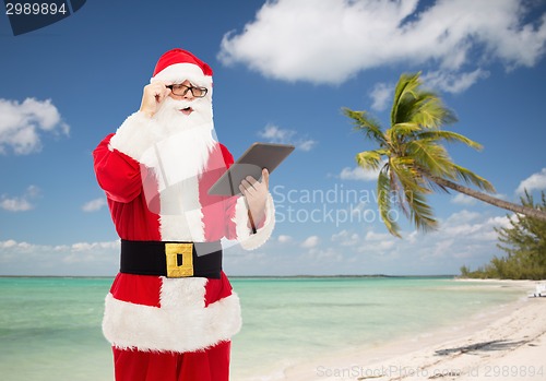 Image of man in costume of santa claus with tablet pc