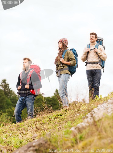 Image of group of smiling friends with backpacks hiking