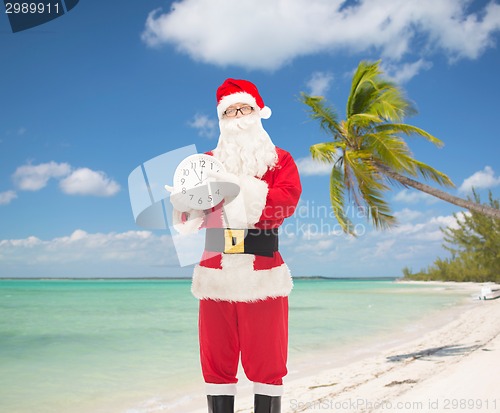 Image of man in costume of santa claus with clock