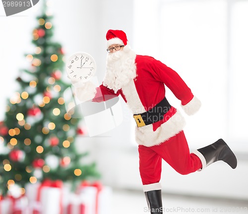 Image of man in costume of santa claus with clock