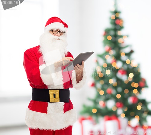 Image of man in costume of santa claus with tablet pc