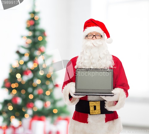 Image of man in costume of santa claus with laptop