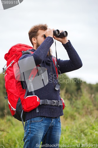 Image of man with backpack and binocular outdoors