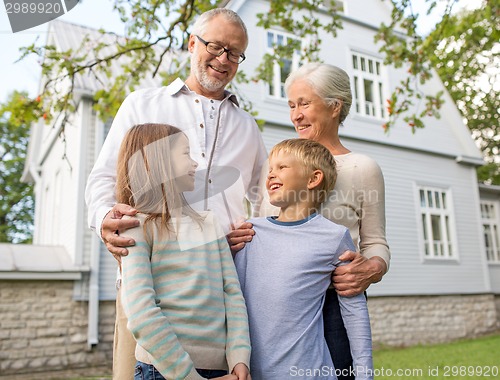 Image of happy family in front of house outdoors