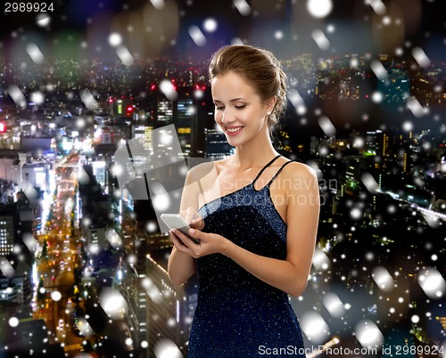 Image of smiling woman in evening dress with smartphone