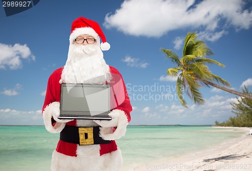 Image of man in costume of santa claus with laptop