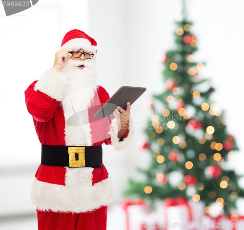 Image of man in costume of santa claus with tablet pc