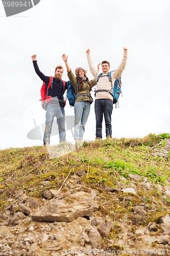 Image of group of smiling friends with backpacks hiking