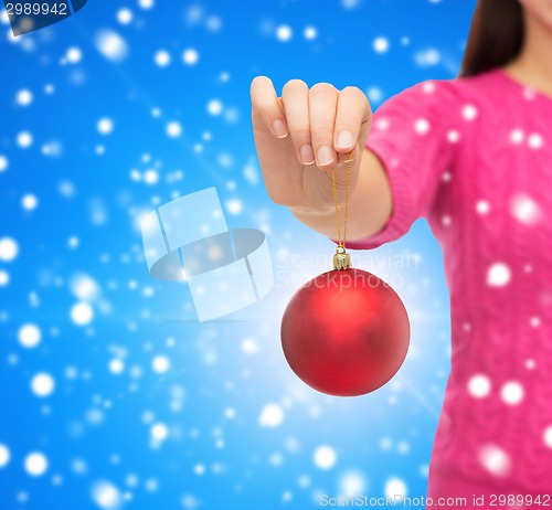 Image of close up of woman in sweater with christmas ball
