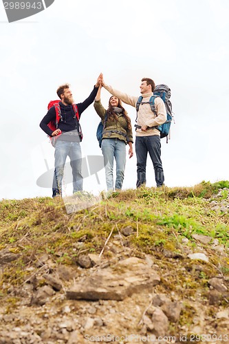 Image of group of smiling friends with backpacks hiking