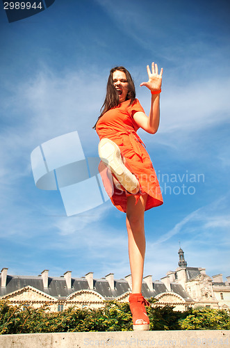 Image of woman in orange dress walking on street