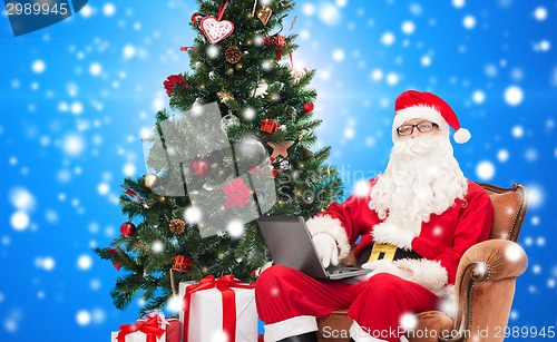 Image of man in costume of santa claus with laptop