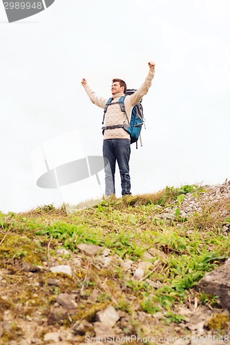 Image of smiling man with backpack hiking