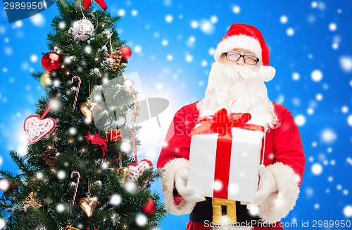 Image of man in costume of santa claus with gift box