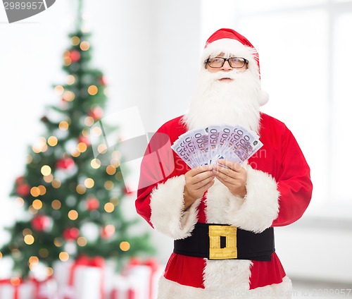 Image of man in costume of santa claus with euro money