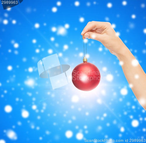 Image of close up of woman in sweater with christmas ball