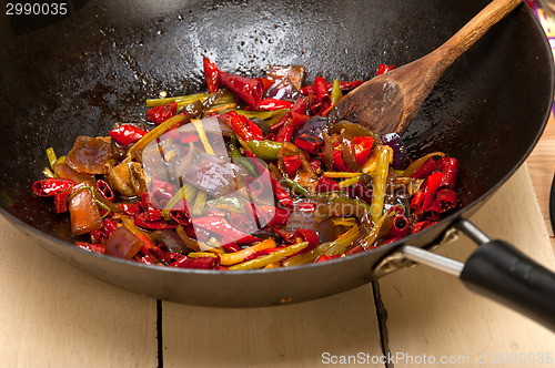 Image of fried chili pepper and vegetable on a wok pan