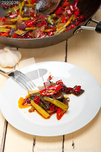 Image of fried chili pepper and vegetable on a wok pan