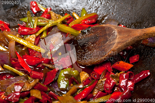 Image of fried chili pepper and vegetable on a wok pan