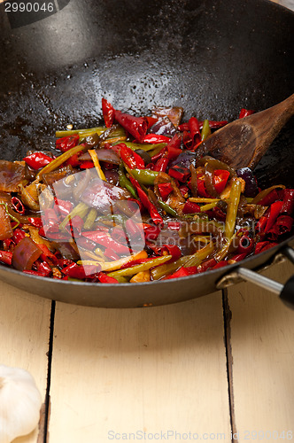 Image of fried chili pepper and vegetable on a wok pan