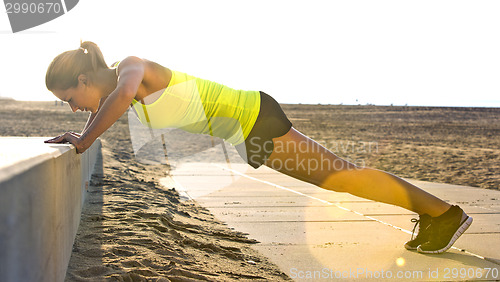 Image of Woman doing Press ups on a beach