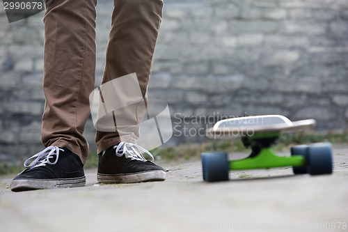 Image of Skateboarder feet and skateboard in urban setting