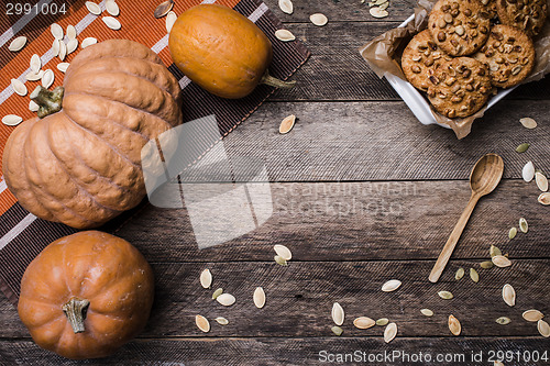 Image of Rustic style pumpkins and cookies with nuts on wood