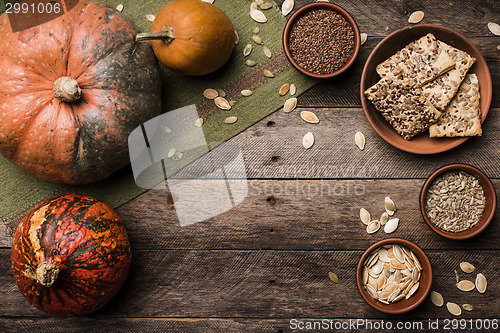 Image of Rustic style pumpkins with cookies and seeds on wood. 