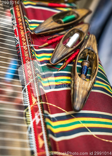 Image of Wooden Weaving shuttles and textured textile