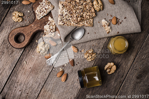 Image of Cookies with seeds  honey  and nuts on wooden table