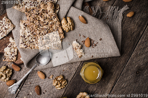Image of Nuts, Cookies with seeds and honey on wooden table