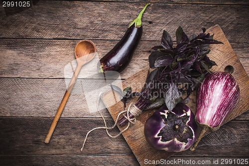 Image of Aubergines and basil on and wooden table