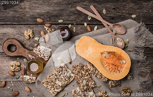 Image of Pumpkin nuts  honey and seeds on wooden table