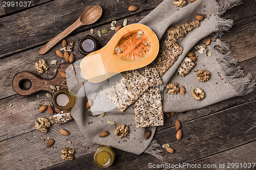 Image of Cut Pumpkin with  honey cookies and seeds on wooden table