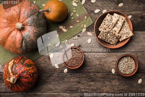 Image of Rustic style autumn pumpkins with cookies and seeds on wood
