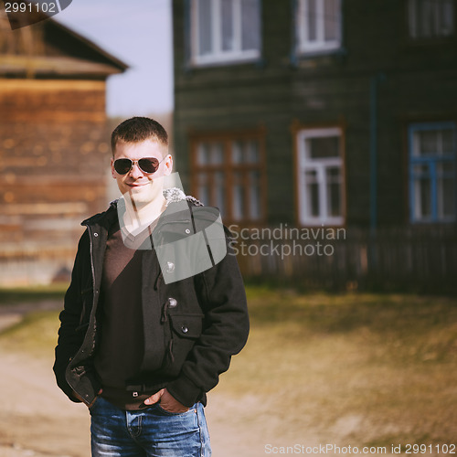 Image of Young Handsome Man Staying Near Old Wooden House In Autumn Or Sp