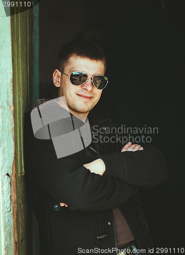 Image of Young Handsome Man Staying Near Old Wooden House In Autumn Or Sp