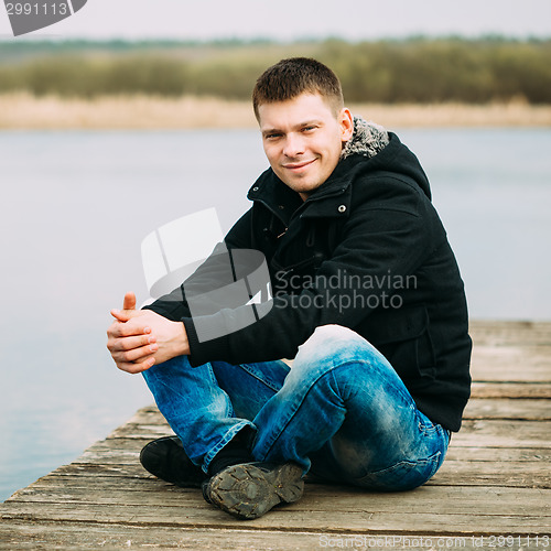 Image of Young Handsome Man Sitting On Wooden Pier, Relaxing,  Thinking, 