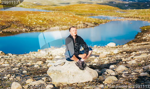 Image of Man Sitting On Stone In Norwegian Mountains