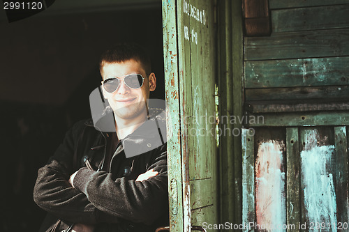 Image of Young Handsome Man Staying Near Old Wooden House In Autumn Or Sp