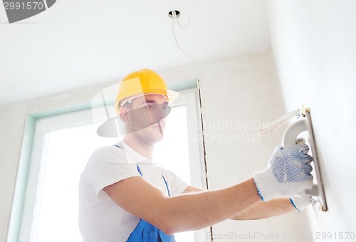 Image of builder with grinding tool indoors