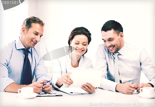 Image of business team looking at tablet pc in office