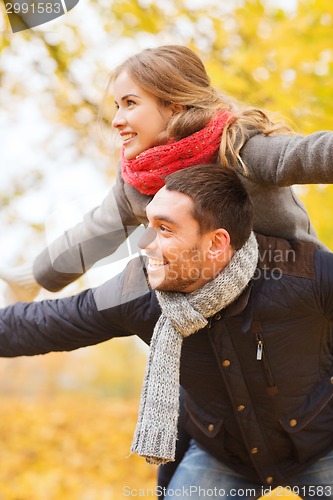Image of smiling couple having fun in autumn park