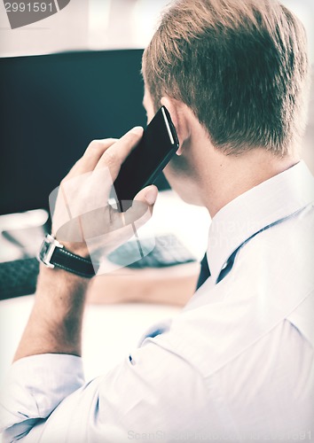 Image of businessman with smartphone in office