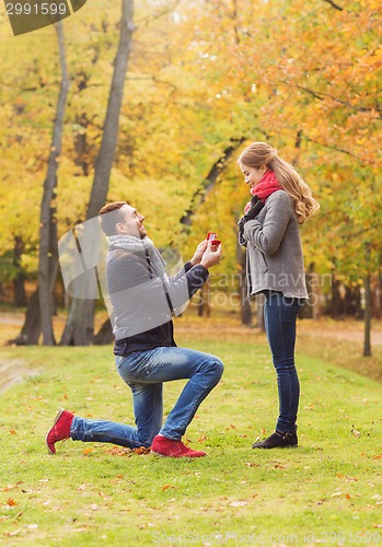 Image of smiling couple with engagement ring in gift box